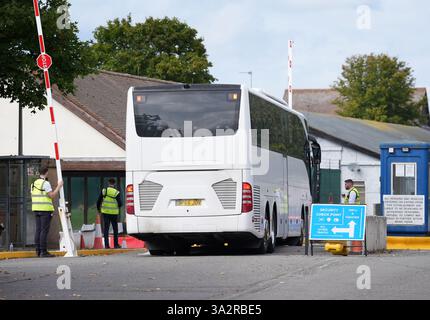 Ein Bus mit einer Gruppe von Menschen, die als Migranten gelten, kommt nach einem Zwischenfall im Kanal im Migrant Processing Centre in Manston, Kent an. Bilddatum: Montag, 23. September 2024. Stockfoto