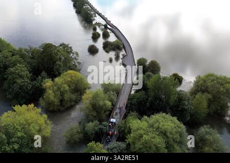 Die Arbeiter schließen die Carlton Road in Harrold, Bedfordshire, wegen Überschwemmungen, nachdem der Fluss Great Ouse seine Ufer platzte. Für Donnerstag wurde eine gelbe Wetterwarnung für mehr starken Regen ausgegeben, als sich Großbritannien von Sturzfluten erholt, bei denen Häuser beschädigt und Reisen unterbrochen wurden. Bilddatum: Mittwoch, 25. September 2024. Stockfoto