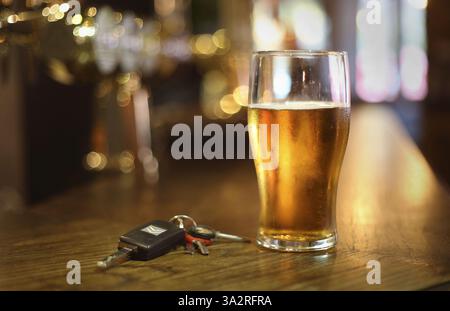 EMBARGOED BIS 0001 MONTAG SEPTEMBER 30 Aktenfoto vom 26/11/14 von einem Bier und einem Satz Autoschlüssel an einer Bar in einem Pub. Hunderte von Menschen wurden mindestens vier Mal beim Trinken beim Fahren erwischt, was zu Aufrufen an die Minister führte, dass sie erwägen sollten, Wiedertäter dazu zu zwingen, Atemgeräte in ihre Autos einzubauen. Insgesamt wurden in den elf Jahren bis zum 20. Juli 27.837 britische Fahrer mehrfach wegen der Straftat verurteilt, wie offizielle Zahlen der Nachrichtenagentur PA bekannt gaben. Ausgabedatum: Montag, 30. September 2024. Stockfoto