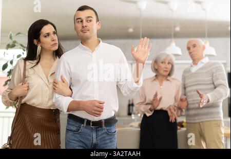 Ein Paar, das mit einem Mann geht, um Streit mit den Eltern zu beenden Stockfoto