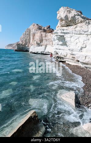 Eine Einzelfigur spaziert entlang der markanten weißen Klippen des Kap Aspro, wo Land auf das türkisfarbene Meer in Limassol, Zypern, trifft. Stockfoto