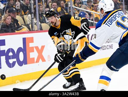 Pittsburgh, Usa. März 2025. Erik Karlsson (65) räumt am Donnerstag, 13. März 2025 in der PPG Paints Arena in Pittsburgh den Puck vom rechten Flügel Alexey Toropchenko (13) ab. Foto von Archie Carpenter/UPI. Quelle: UPI/Alamy Live News Stockfoto