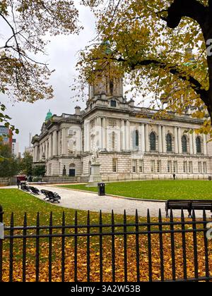 Herbstlaub umrahmt das historische Belfast City Hall in Nordirland an einem bewölkten Tag. Stockfoto