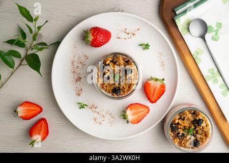 Griechischer Joghurt mit Erdbeeren und Müsli mit Müsli und Nüssen. Stockfoto