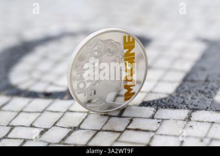 NUR Eine Sammlermünze mit John Lennon und dem Wort „Imagine“ wird im Strawberry Fields Memorial im New Yorker Central Park, USA, von der Royal Mint als Teil ihrer „Music Legends“-Münzserie vorgestellt. Ausgabedatum: Freitag, 14. März 2025. Stockfoto