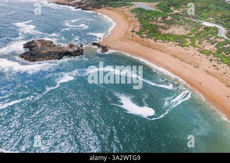 Aus der Vogelperspektive des geschwungenen Sandstrangs führt zu einem Felsvorsprung bei Beachport an der Kalksteinküste in South Australia. Stockfoto