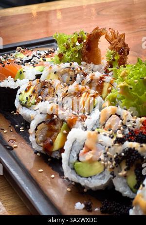 Ein Teller mit frischen verschiedenen Sushi-Brötchen im Restaurant auf einem Tisch Stockfoto