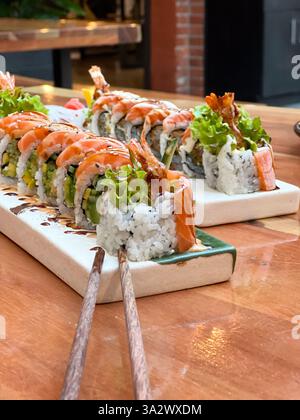 Ein Teller mit frischen verschiedenen Sushi-Brötchen im Restaurant auf einem Tisch Stockfoto