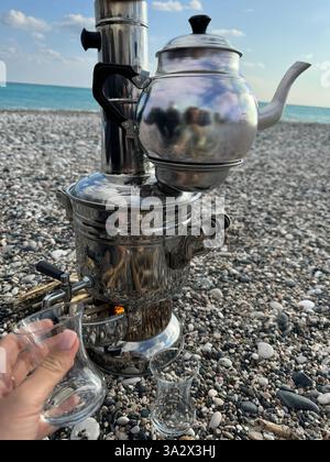 Genießen Sie Tee am Strand mit einem traditionellen Samovar an einem sonnigen Tag Stockfoto