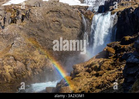 Strompgljufrafoss (Strompur) Wasserfall unterhalb des großen Dynjandi Wasserfalls in Westfjorden, Island mit vulkanischen Felsen und einem Regenbogen. Stockfoto
