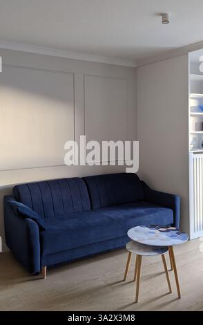 Modernes Wohnzimmer mit blauem Sofa und weißen Wänden. Hochwertige Fotos Stockfoto