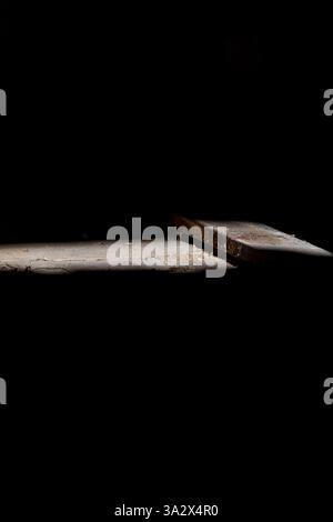 Ein dramatischer Lichtschacht beleuchtet einen staubigen Holzboden in einer alten Hütte und offenbart alte Dielen und verstreuten Schmutz, während die Umgebung dunkel ist Stockfoto