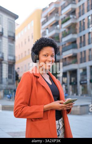 Junge Frau, die Musik in urbaner Umgebung genießt Stockfoto