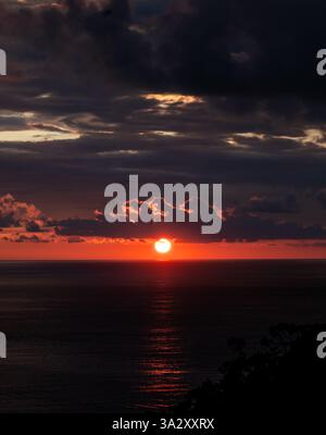 Wunderschöner orangener Sonnenuntergang mit Wolken über dem Ozean in Costa Rica. Stockfoto