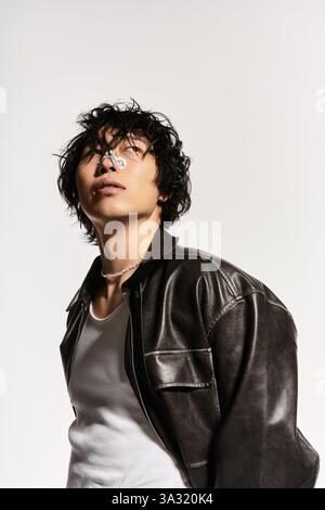 Stilvoller asiatischer Mann mit Gips auf der Nase, der in einem modernen Studio posiert. Stockfoto