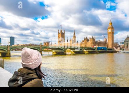 Herrlicher Panoramablick auf eine Frau mit rosa Strickmütze, die auf die Westminster Bridge und den Palast von Westminster blickt, einschließlich Big Ben bei einer Erkältung... Stockfoto