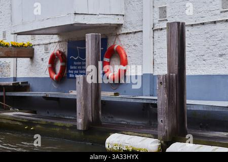Rettungsschwimmer an einer Hafenmauer in der Nähe des Wasserwegs. Stockfoto