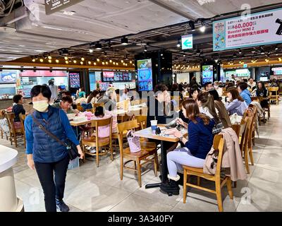 Taipeh, Taiwan, große Menschenmengen, sitzen an Tischen, im Food Court, Woman Walking, Front, Shopping, Taiwanesisches Kaufhaus, Stockfoto