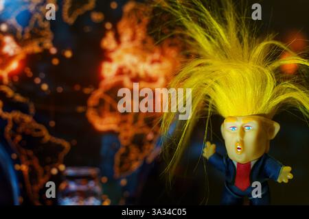 Bobruisk, Weißrussland - 6. März 2025: Die farbenfrohe Figur symbolisiert einen politischen Führer, der vor dem Hintergrund einer Weltkarte steht. Stockfoto