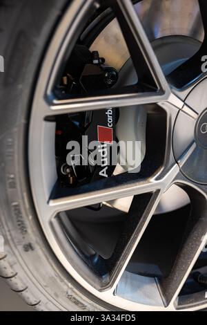 07.03.2025 , München International Airport, Deutschland. Audi e-tron GT Carbon Scheibenbruch und Bremssattel am hinteren Aluminiumrad. Nahaufnahme Detailaufnahme, nein Stockfoto