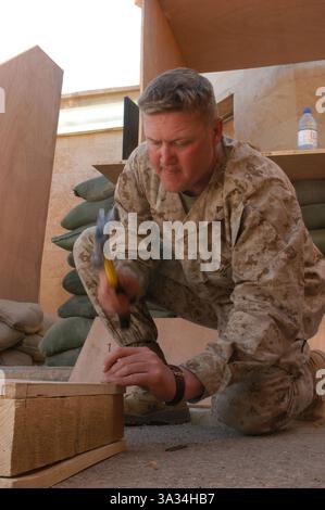 23. März 2004; Camp Hurricane Point, Irak; Lance CPL. BRETT T. NEWMAN, Infanterie des 2. Bataillons, 4. Marine-Regiment, 1. Marine-Division, baut hier Möbel für Büroräume. Im März 1988 trat er im Alter von 18 Jahren dem Marine Corps bei. Nach mehreren Einsätzen und einer Tour nach Kuwait für den Ersten Golfkrieg 1990 entschied sich Newman, das Marine Corps zu verlassen und seinen Traum zu verwirklichen, High School Lehrer und Basketballtrainer zu werden. Newman aus Albuquerque, N.M., meldete sich nach einer zehnjährigen Pause wieder zum Korps und ist derzeit hier, um die Operation Iraqi Freedom II zu unterstützen Stockfoto