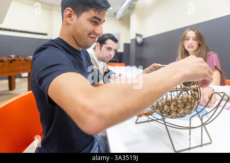 Eine Gruppe von Freunden genießt ein lebhaftes Bingo-Spiel in einem Freizeitzentrum für psychische Gesundheit, das Entspannung und Bindung in einer unterstützenden Umgebung fördert. Ideal für Stockfoto