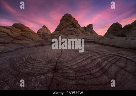 Majestätische Aussicht auf Coyote Buttes in der Paria Canyon-Vermilion Cliffs Wilderness, Arizona, mit markanten Felsformationen unter einer pulsierenden Dämmerung Stockfoto