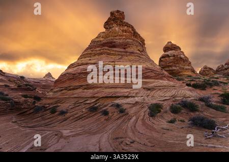 Der lebhafte Sonnenuntergang beleuchtet die wirbelnden Sandsteinformationen der Coyote Buttes in der Paria Canyon-Vermilion Cliffs Wilderness, Arizona, und hebt den Himmel hervor Stockfoto