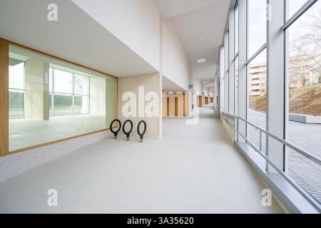 Mit einem modernen, luftigen Korridor mit minimalistischem Design, lebhaften Fenstern und effizientem Energieverbrauch verbindet dieses Foto nachhaltige Architektur mit c Stockfoto