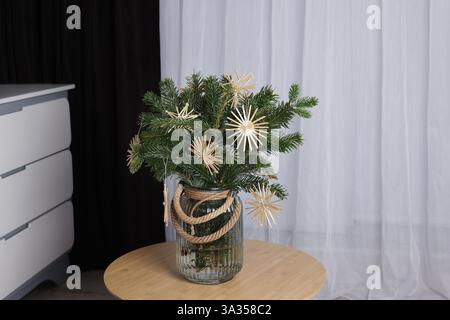Schöne Weihnachtskomposition aus dekorierten Tannenzweigen auf dem Tisch drinnen Stockfoto