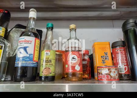 Ein Regal mit verschiedenen Flaschen und Behältern, Gewürzen und Lebensmittelzutaten, einschließlich Sojasauce, Fischsauce, Essig, Malaysia Stockfoto