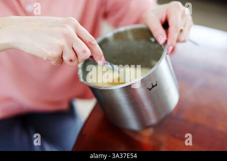 Frau hat rohe Eier in einer Glasschale auf Marmoroberfläche von Hand gemischt Stockfoto