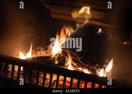 Ein wunderschöner Blick auf brennende Baumstämme in einem Herd, die warme und einladende Flammen ausstrahlen. Fängt perfekt die Atmosphäre eines gemütlichen, ruhigen Abends ein Stockfoto