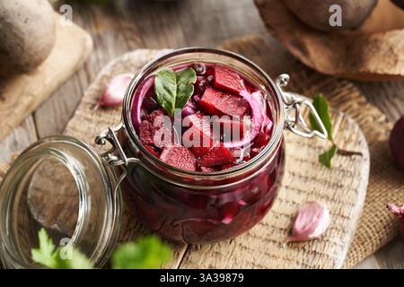 Zubereitung von fermentiertem Rübenkwass in einem Glas aus frischer Rote Bete, Zwiebeln, Knoblauch und Gewürzen Stockfoto