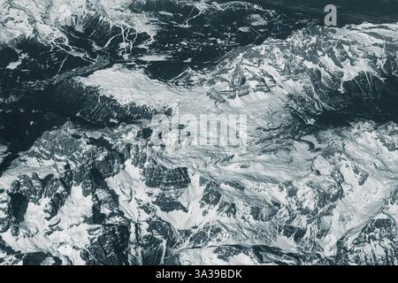 Blick aus der Vogelperspektive auf hohe, schneebedeckte felsige Berge. Alpenlandschaft. Schönheit in der Natur. Unzugängliche Berggipfel. Raues Klima. Sehen Sie sich den an Stockfoto