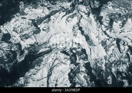Blick aus der Vogelperspektive auf hohe, schneebedeckte felsige Berge. Alpenlandschaft. Schönheit in der Natur. Unzugängliche Berggipfel. Raues Klima. Sehen Sie sich den an Stockfoto