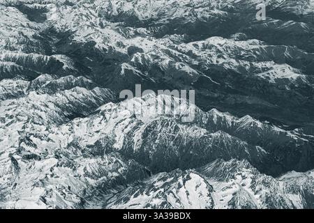 Blick aus der Vogelperspektive auf hohe, schneebedeckte felsige Berge. Alpenlandschaft. Schönheit in der Natur. Unzugängliche Berggipfel. Raues Klima. Sehen Sie sich den an Stockfoto