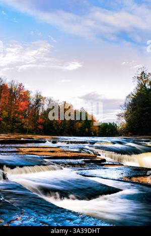 Ein ruhiger Blick auf den Assomption River im Herbst, mit leuchtenden Herbstfarben rund um das ruhige Wasser. Stockfoto