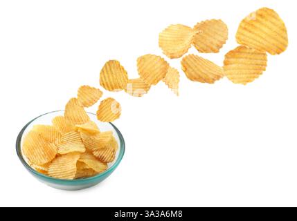 Leckere Kartoffelchips fallen in Schüssel auf weißem Hintergrund Stockfoto