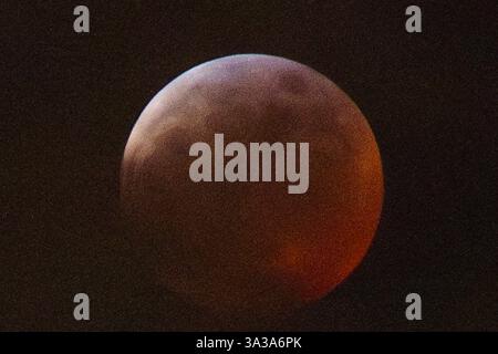 Blood Moon Eclipse in Alaska Anchorage, Alaska 13. März 20205: Eine faszinierende totale Mondfinsternis, auch bekannt als Blood Moon, wirft ein tiefrotes Leuchten über den Nachthimmel in Anchorage, Alaska. Während der Schatten der Erde den Mond vollständig umhüllt, fesselt das seltene himmlische Ereignis Sternenbeobachter und Fotografen gleichermaßen. Trotz teilweiser Wolkenbedeckung bleibt das Phänomen von erhöhten Orten wie Anchorage City aus sichtbar und bietet einen atemberaubenden Blick auf dieses astronomische Spektakel. Die Sonnenfinsternis erreichte ihren Höhepunkt um 22:58 Uhr AKDT und zog die Aufmerksamkeit der Skywatcher in der Region auf sich. Copyright: XHASANxAKBASx Stockfoto