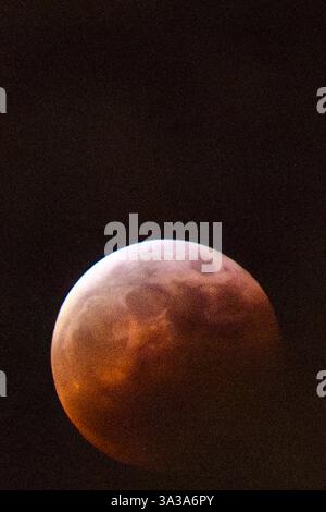 Blood Moon Eclipse in Alaska Anchorage, Alaska 13. März 20205: Eine faszinierende totale Mondfinsternis, auch bekannt als Blood Moon, wirft ein tiefrotes Leuchten über den Nachthimmel in Anchorage, Alaska. Während der Schatten der Erde den Mond vollständig umhüllt, fesselt das seltene himmlische Ereignis Sternenbeobachter und Fotografen gleichermaßen. Trotz teilweiser Wolkenbedeckung bleibt das Phänomen von erhöhten Orten wie Anchorage City aus sichtbar und bietet einen atemberaubenden Blick auf dieses astronomische Spektakel. Die Sonnenfinsternis erreichte ihren Höhepunkt um 22:58 Uhr AKDT und zog die Aufmerksamkeit der Skywatcher in der Region auf sich. Copyright: XHASANxAKBASx Stockfoto