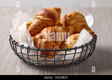 Frisch gebackene Croissants auf rustikalem Holztisch Stockfoto