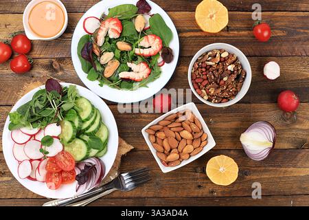 Gemüsesalat mit Garnelen, Gurke, Kirschtomaten, Radieschen, Honig, Nüsse und frische Rucola, gesundes natürliches Frühstück mit Zitrone, Detox Diet con Stockfoto
