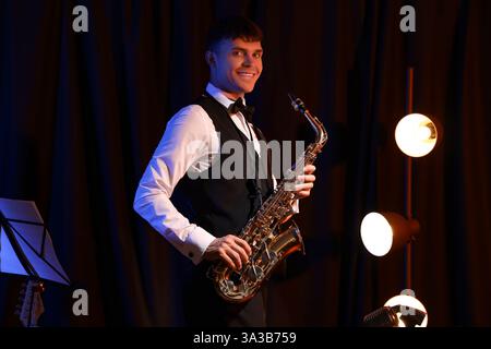 Männlicher Künstler mit Saxophon auf der Bühne Stockfoto
