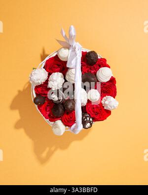 Blick von oben auf einen romantischen Korb voller roter Rosen und Erdbeeren mit Schokoladenüberzug Stockfoto