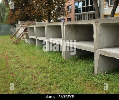 Betonplatten werden auf dem Gras gestapelt. Reparatur der Wasserversorgung. Stockfoto