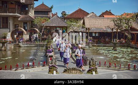 Touristen in Sarongs besuchen den Ubud Wasserpalast am Saraswati Tempel (Pura Taman Saraswati) in Ubud, Bali, Indonesien. Stockfoto