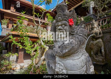 Aufwändig geschnitzte Steinstatue im Garten des Hotel Tjampuhan Spa in Ubud, Bali, Indonesien. Stockfoto