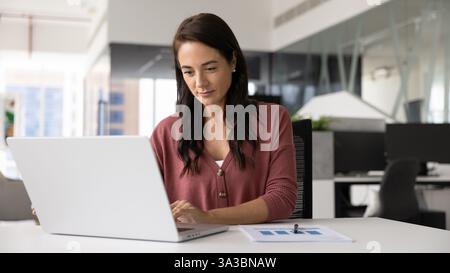 Fokussierte, positive Geschäftsfrau, die an einem Projekt arbeitet Stockfoto