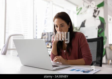 Durchdachter, seriöser Business Project Manager, der am Laptop arbeitet Stockfoto